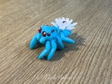 Lichtblaue 3D-gedruckte Spinne mit weißer Seerose und dunkelroten Augen – 5 cm Dekorationsfigur